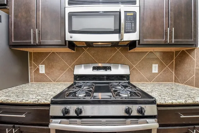a stove top oven sitting inside of a kitchen