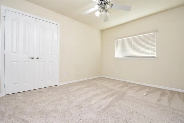 an empty room with a chandelier fan