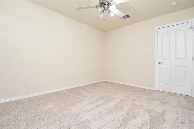 an empty room with a chandelier fan