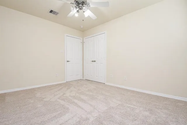 an empty room with a chandelier fan