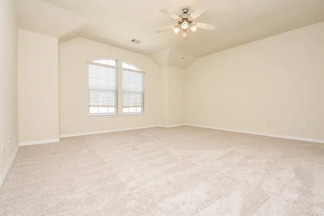 an empty room with a window and a ceiling fan