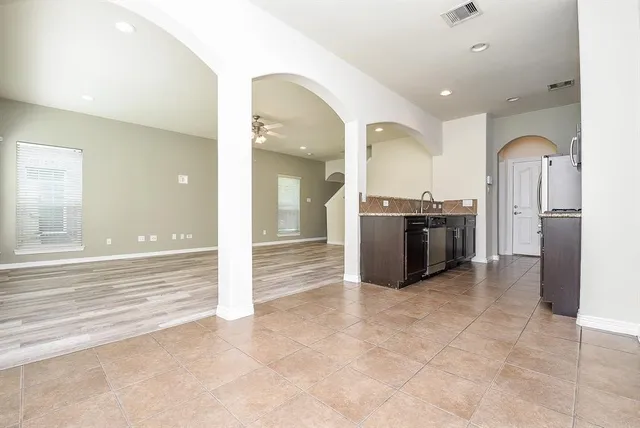 a view of a kitchen with stainless steel appliances granite countertop a refrigerator and a sink