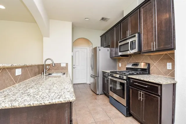 a kitchen with stainless steel appliances granite countertop a stove and a microwave