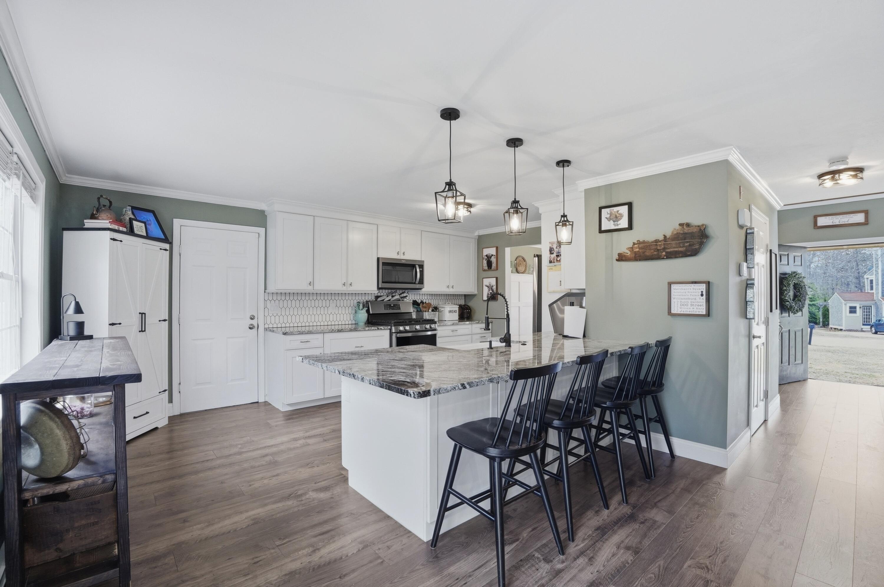 3 Dover Lane Buzzards Bay, MA 02532 - Photo 6 of 51 a kitchen with stainless steel appliances a dining table chairs stove and cabinets