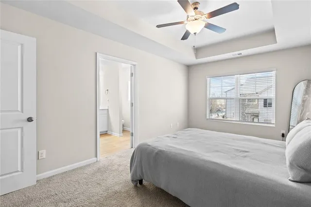 a spacious bedroom with a bed and a chandelier