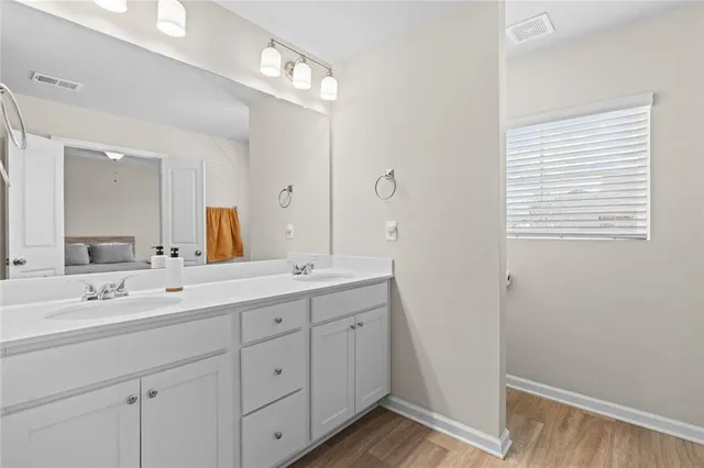 a spacious bathroom with a double vanity sink a mirror and a shower