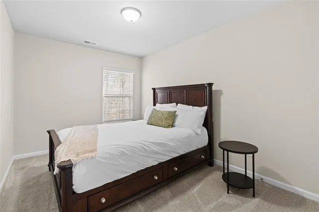 a bed sitting in a bedroom next to a window