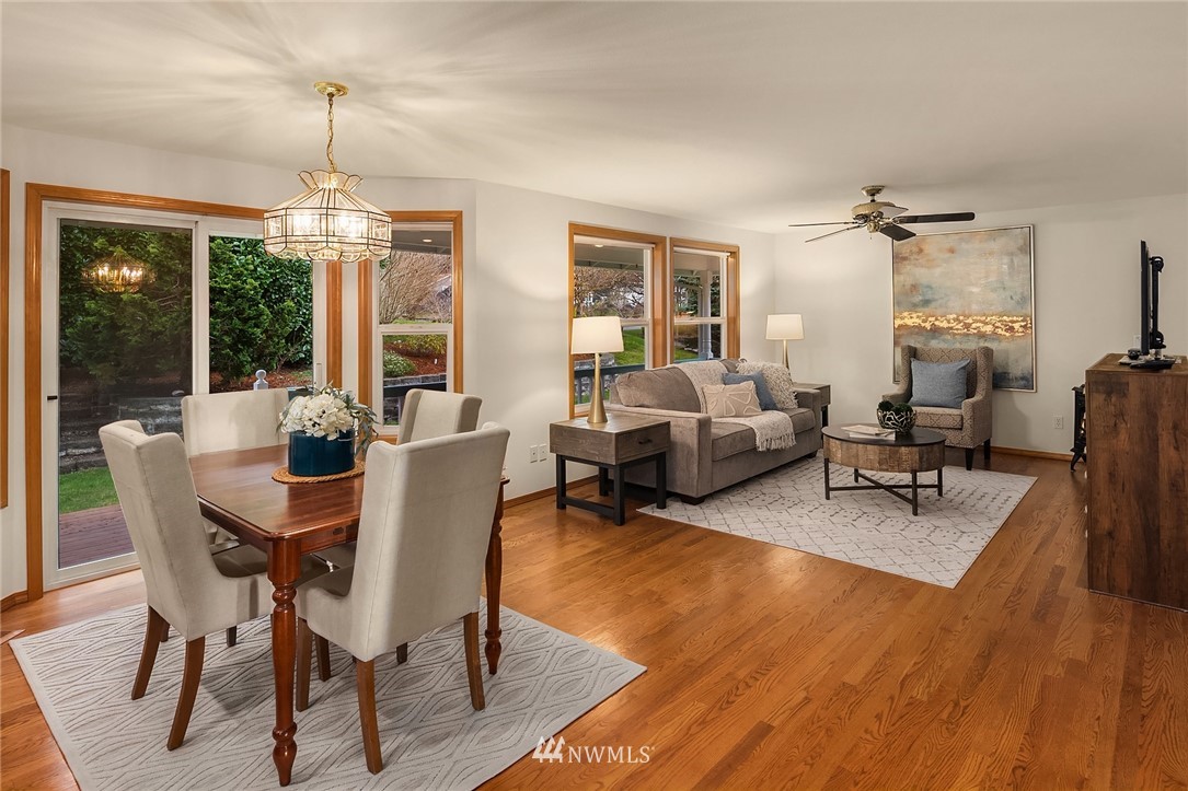 14010 282nd Lane Northeast Duvall, WA 98019 - Photo 12 of 31 a dining room with wooden floor a chandelier a glass table and chairs