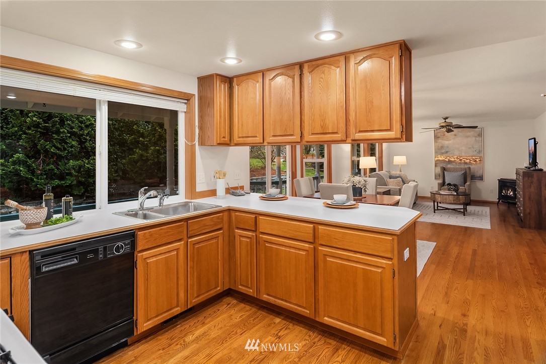 14010 282nd Lane Northeast Duvall, WA 98019 - Photo 9 of 31 a kitchen with stainless steel appliances granite countertop sink stove and wooden cabinets