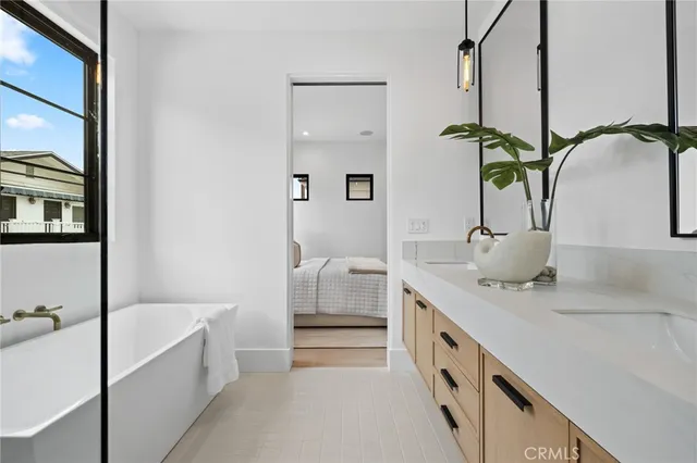 a bathroom with a double vanity sink a mirror and bathtub