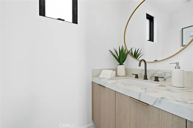 a bathroom with a granite countertop sink and a mirror