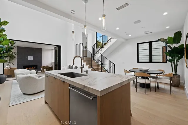 a open kitchen with stainless steel appliances granite countertop a sink a stove and a refrigerator