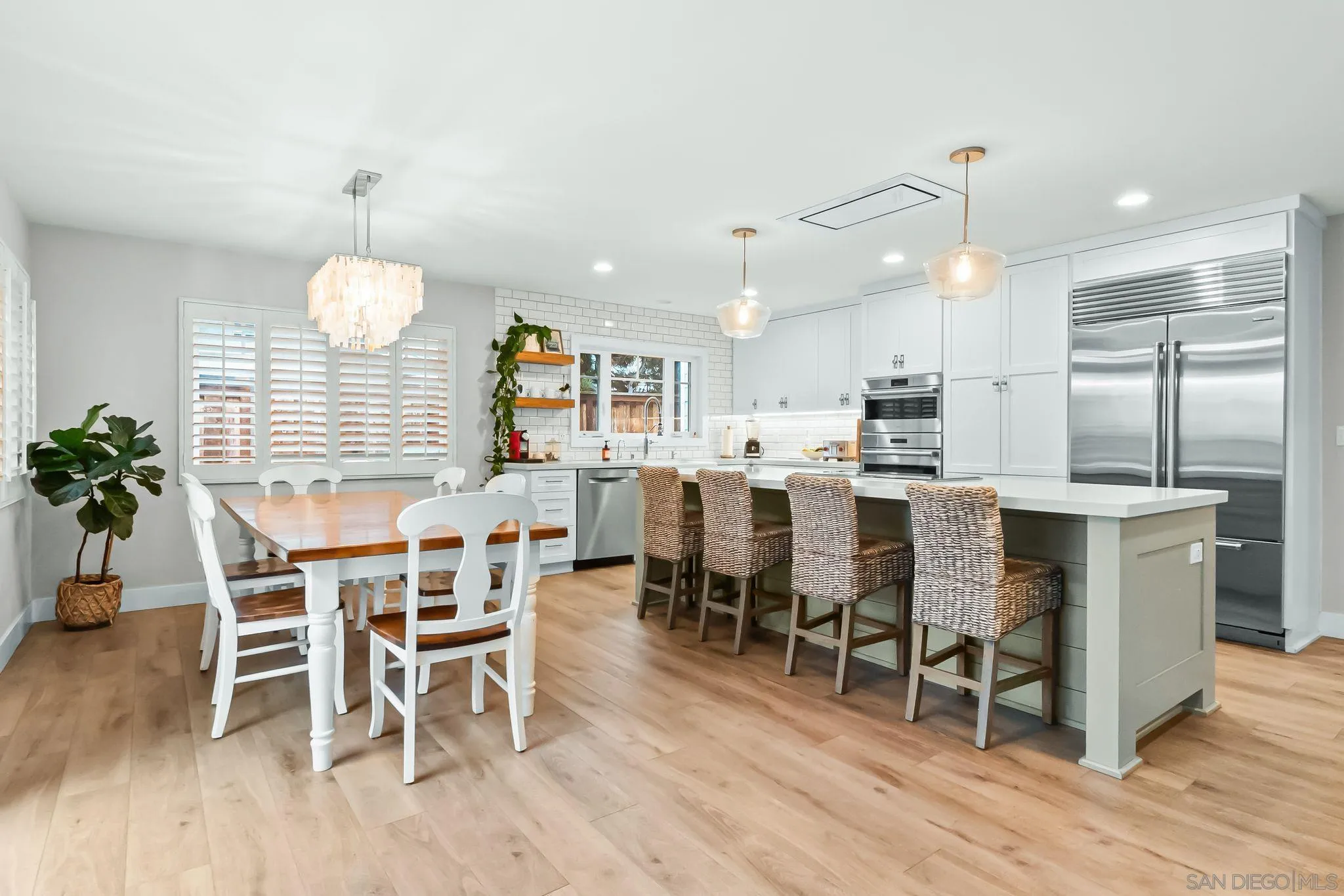 13814 Recuerdo Drive Del Mar, CA 92014 - Photo 9 of 31 a kitchen with stainless steel appliances kitchen island granite countertop a table chairs and a refrigerator