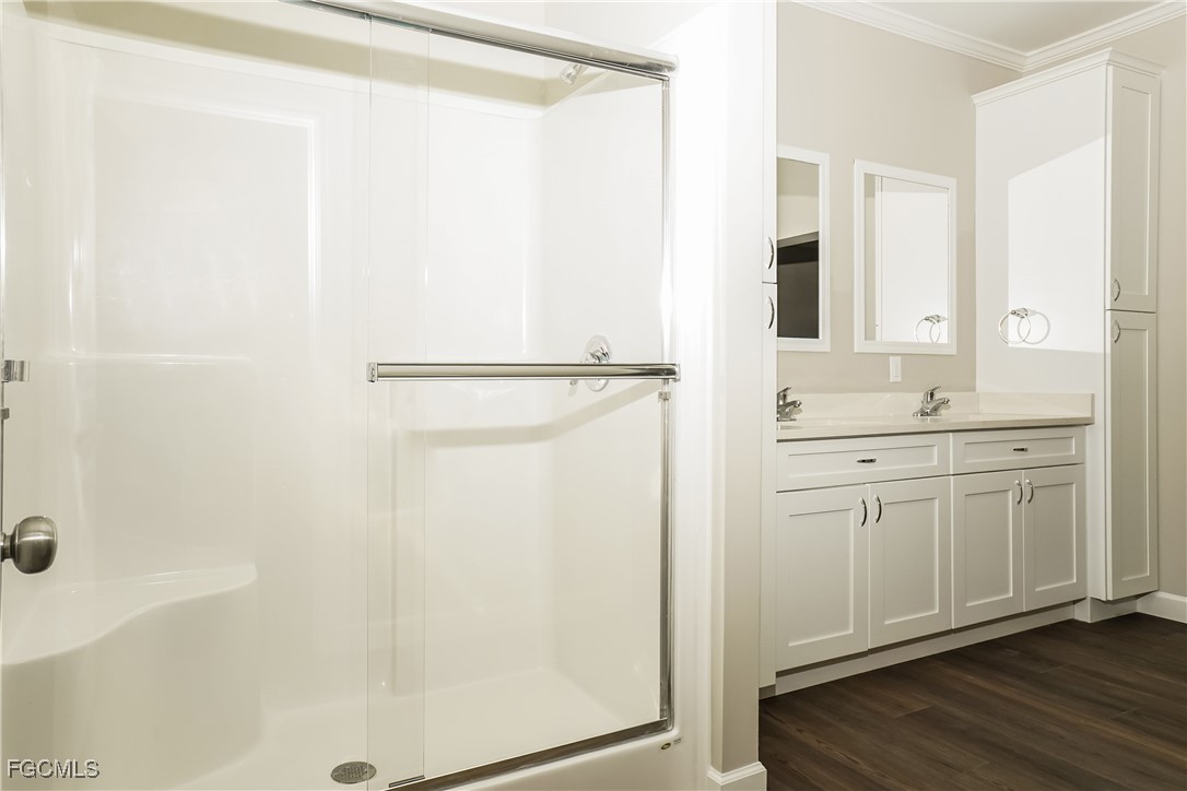 12315 Tangier Street North Port, FL 34287 - Photo 10 of 16 a bathroom with a double vanity sink a mirror and a shower