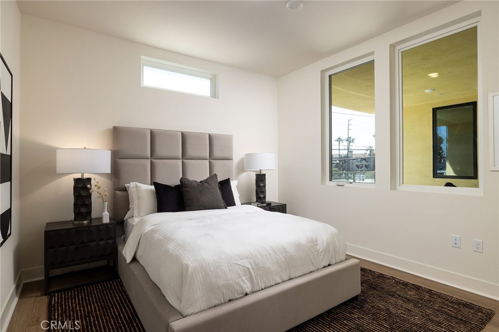 414 Main Street, Unit 310 Huntington Beach, CA 92648 - Photo 15 of 25 a bedroom with a bed and wooden floor