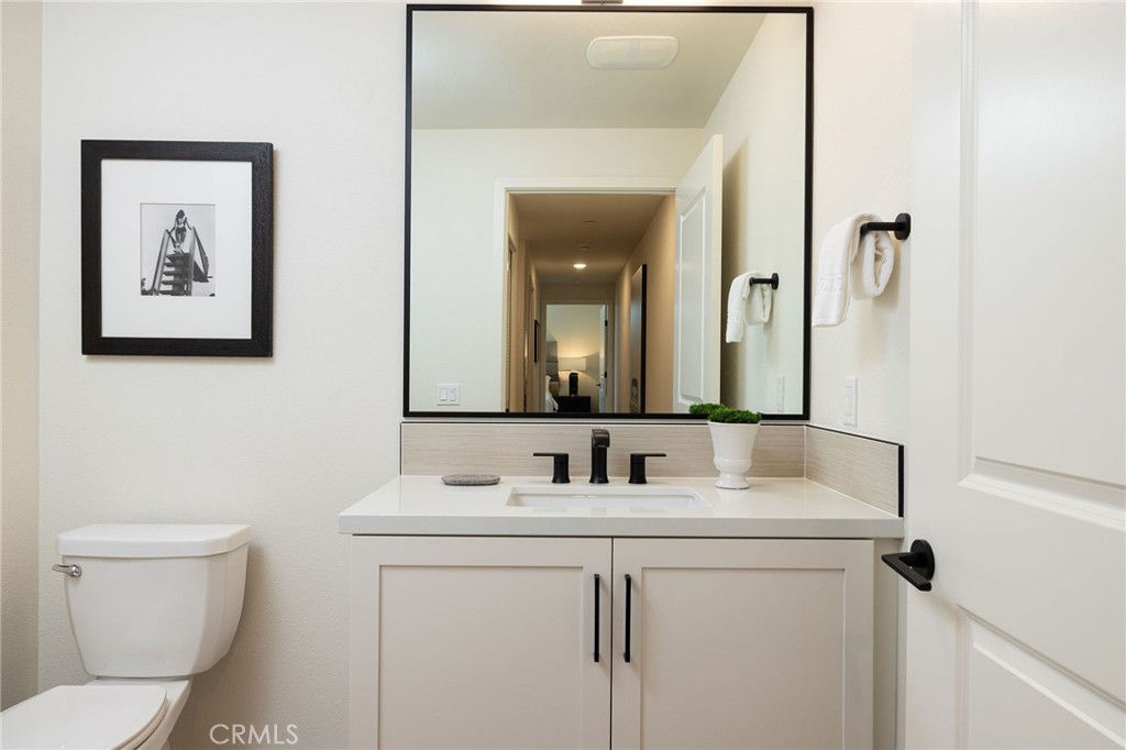 414 Main Street, Unit 310 Huntington Beach, CA 92648 - Photo 17 of 25 a bathroom with a toilet sink and mirror