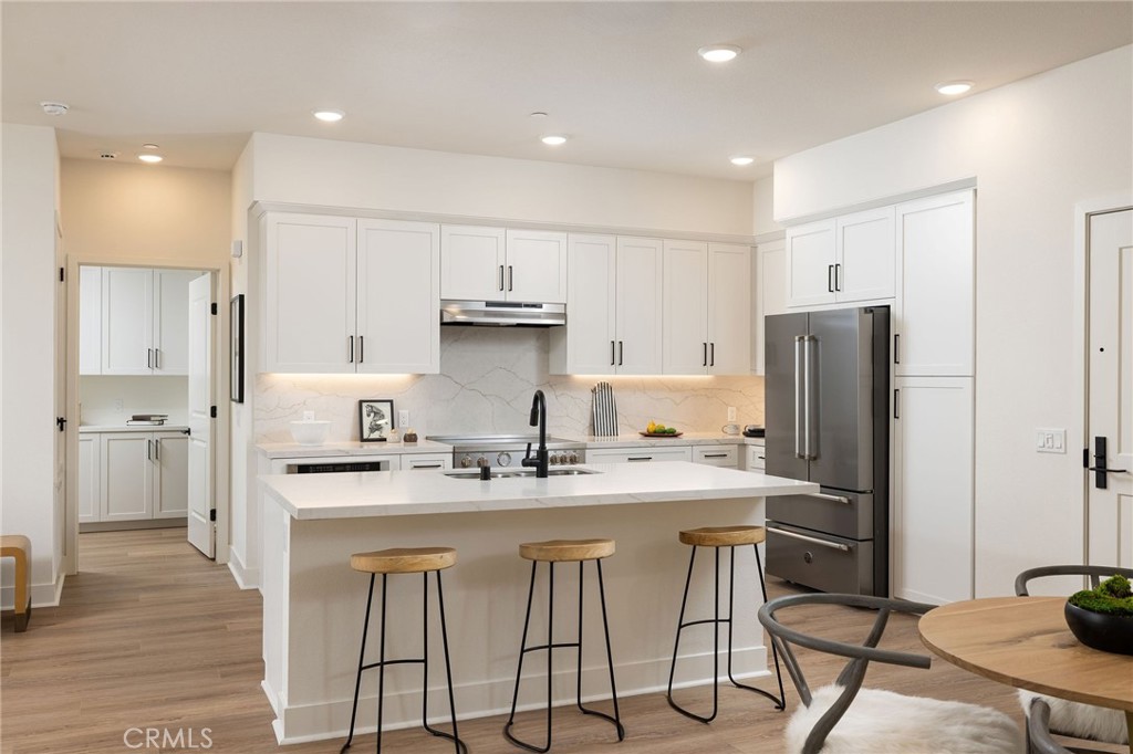 414 Main Street, Unit 310 Huntington Beach, CA 92648 - Photo 7 of 25 a kitchen with stainless steel appliances granite countertop a sink a stove a refrigerator and cabinets