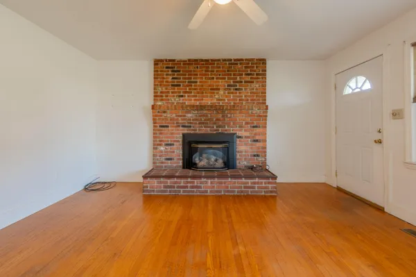 wooden floor fireplace and windows in an empty room