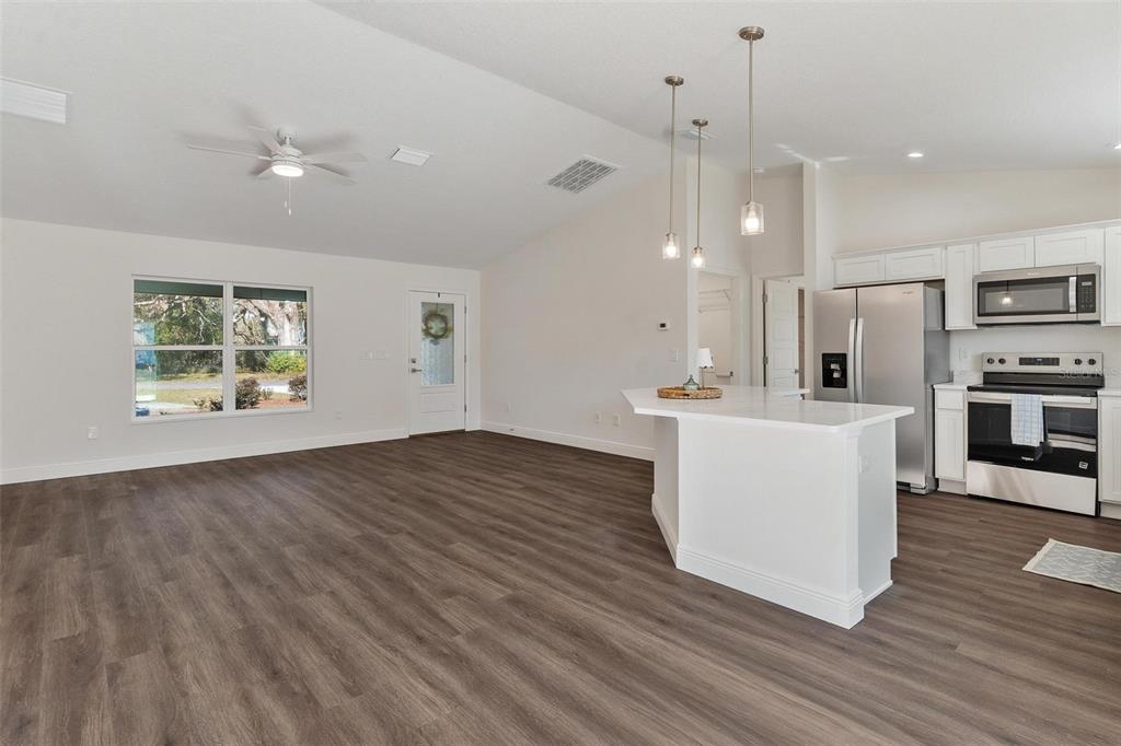 2011 Edgewood Avenue Leesburg, FL 34748 - Photo 13 of 44 a view of a kitchen with kitchen island a sink wooden floor and a refrigerator