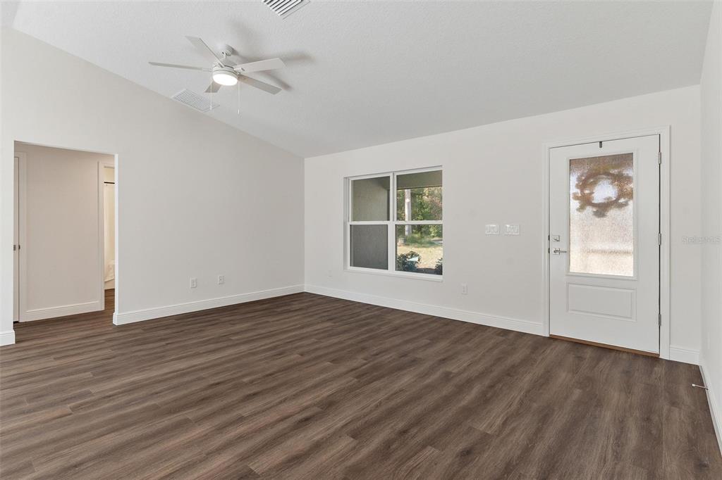 2011 Edgewood Avenue Leesburg, FL 34748 - Photo 10 of 44 an empty room with wooden floor chandelier fan and windows