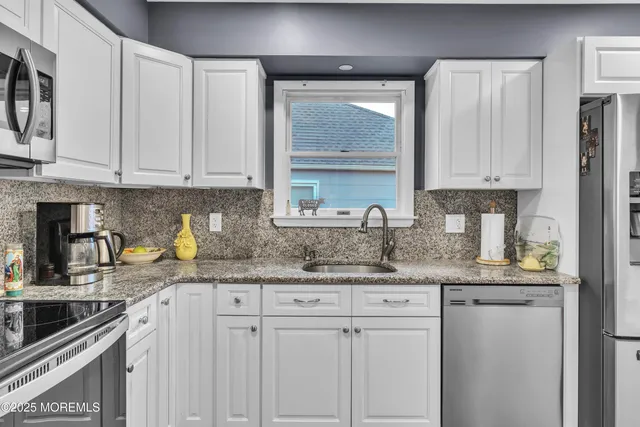 a kitchen with granite countertop a sink stove and cabinets