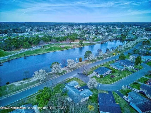 an aerial view of a residential houses with outdoor space and lake view