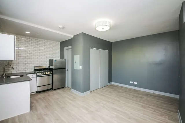 a kitchen with stainless steel appliances granite countertop a refrigerator and a stove top oven