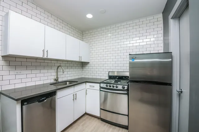 a kitchen with granite countertop a sink stove and cabinets