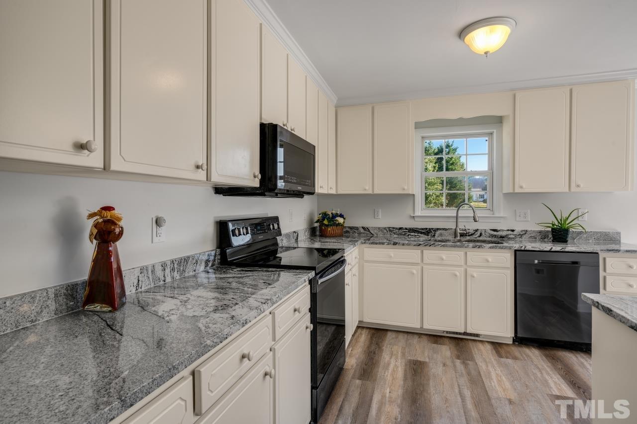 704 Rudy Drive Clayton, NC 27520 - Photo 11 of 30 a kitchen with stainless steel appliances granite countertop a sink a stove and cabinets