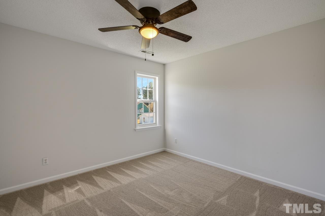 704 Rudy Drive Clayton, NC 27520 - Photo 13 of 30 an empty room with a window and a fan