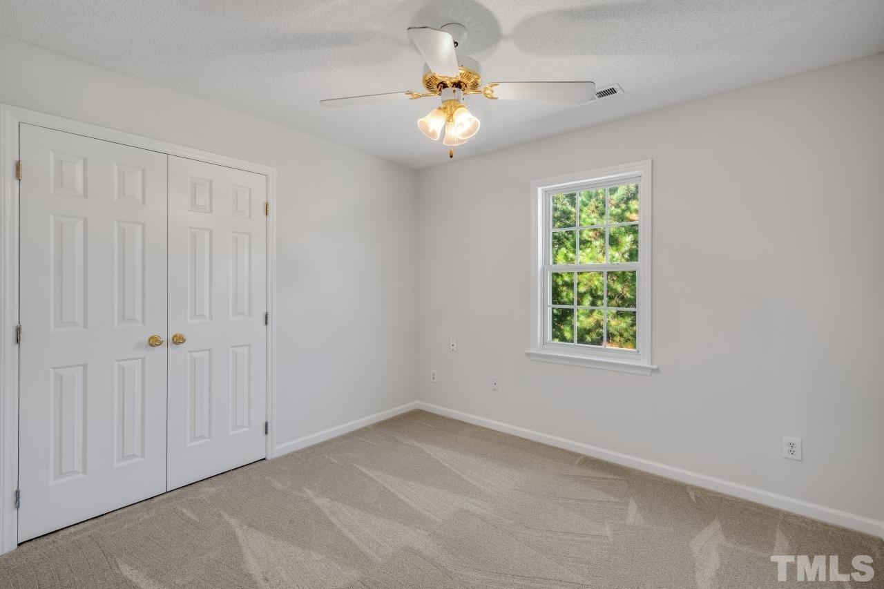 704 Rudy Drive Clayton, NC 27520 - Photo 15 of 30 an empty room with a window and a ceiling fan