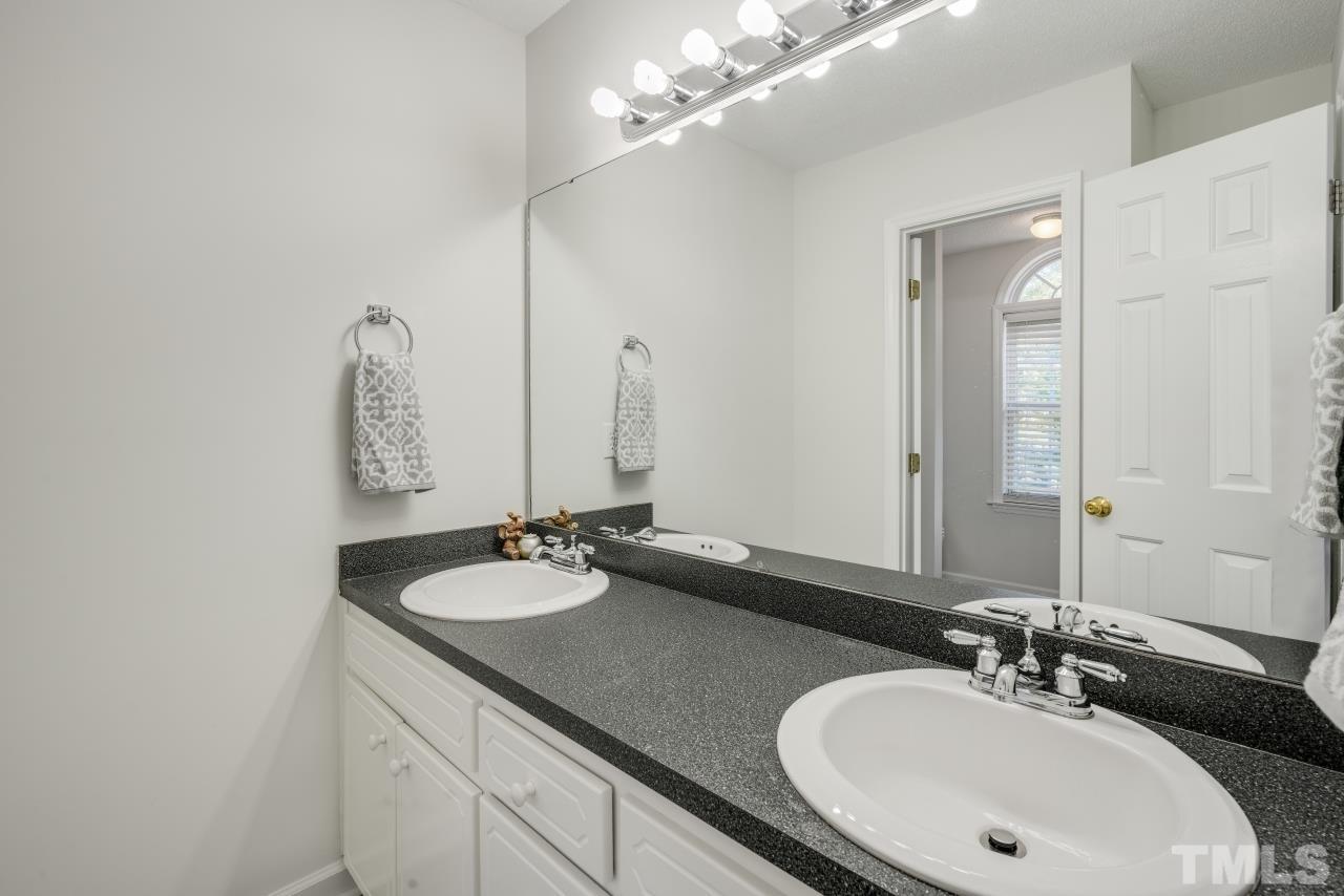 704 Rudy Drive Clayton, NC 27520 - Photo 17 of 30 a bathroom with a sink and a mirror