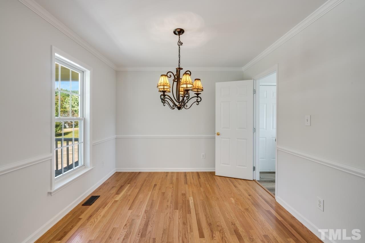 704 Rudy Drive Clayton, NC 27520 - Photo 4 of 30 a view of a room with wooden floor a ceiling fan and windows