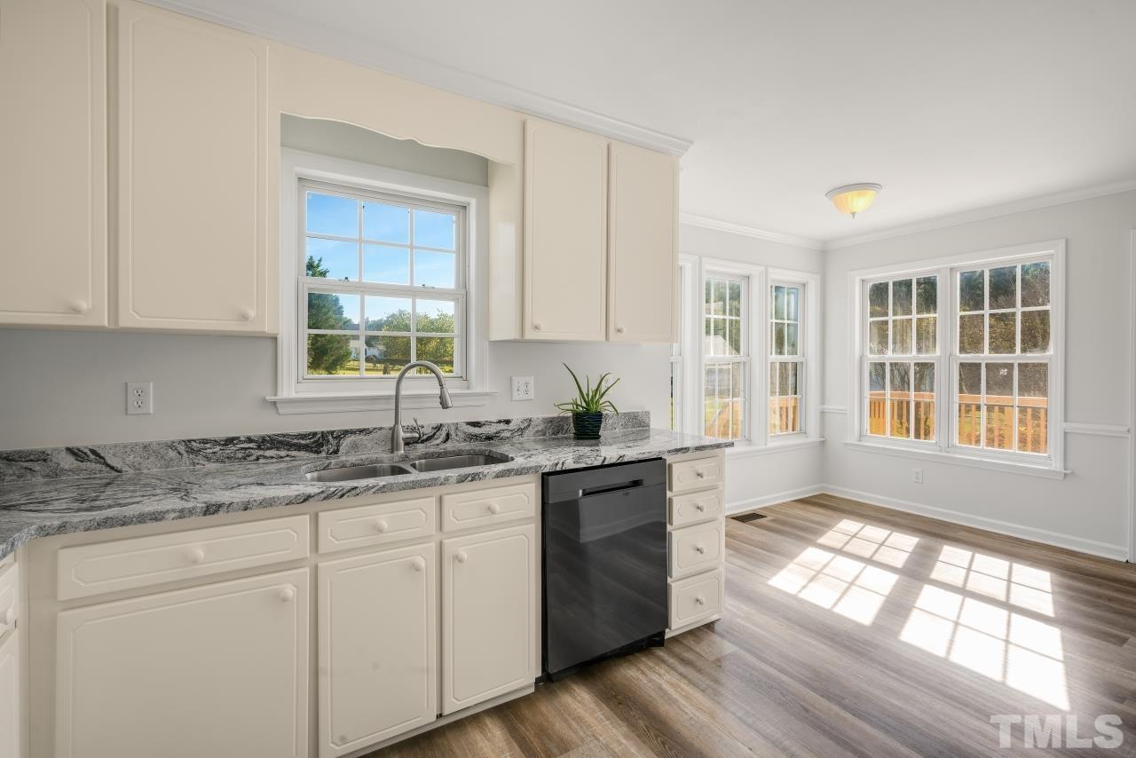 704 Rudy Drive Clayton, NC 27520 - Photo 7 of 30 a kitchen with stainless steel appliances granite countertop wooden floors and sink