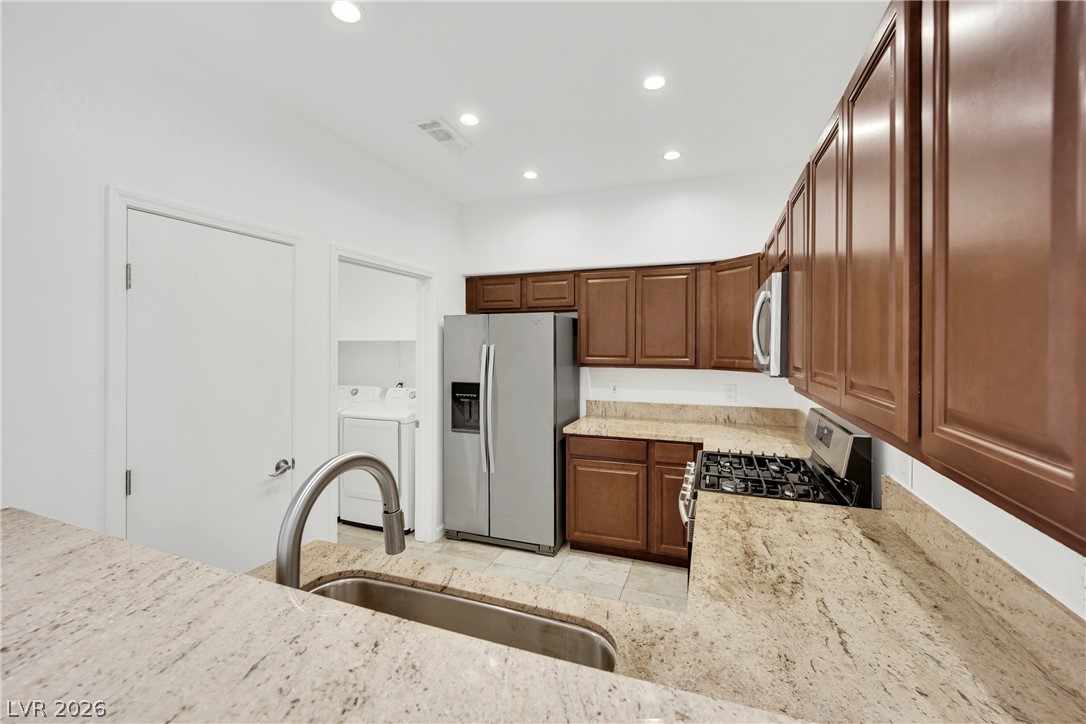 8725 West Flamingo Road, Unit 110 Las Vegas, NV 89147 - Photo 14 of 30 Granite counters and rich wood cabinetry create a functional, inviting kitchen space.