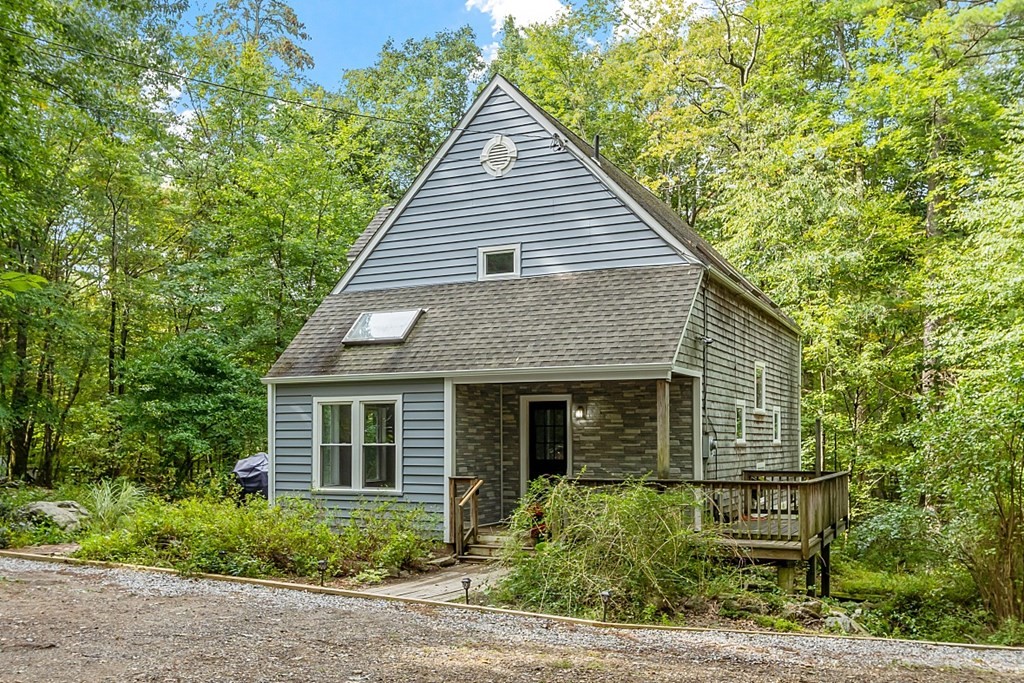 a front view of a house with a yard and potted plants
