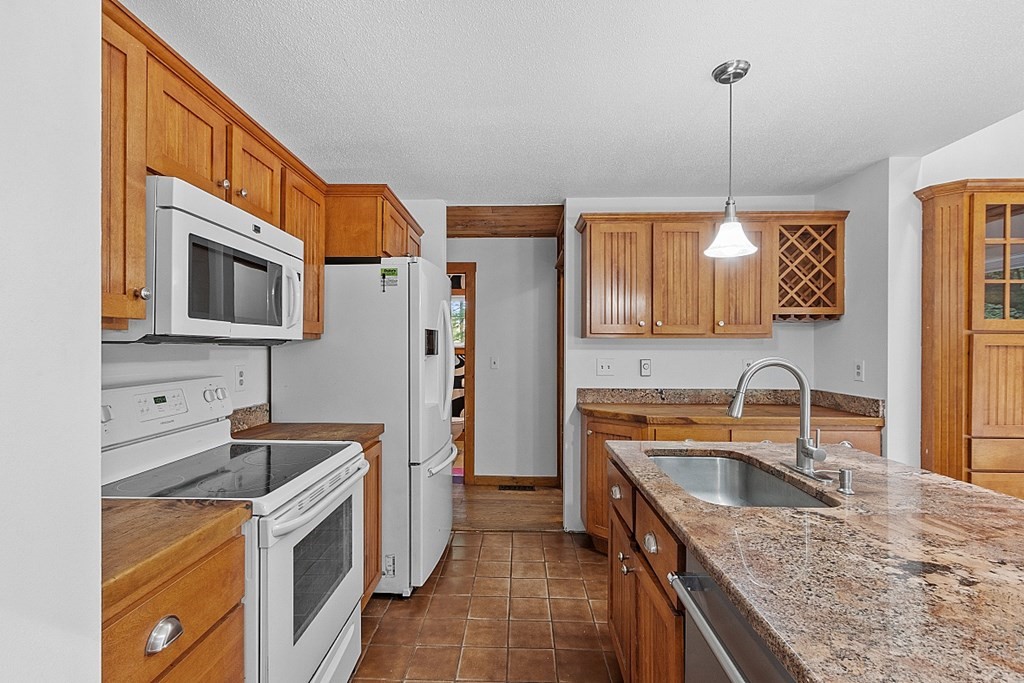 444 Old Dana Road Barre, MA 01005 - Photo 6 of 39 a kitchen that has a sink a microwave a refrigerator and wooden cabinets