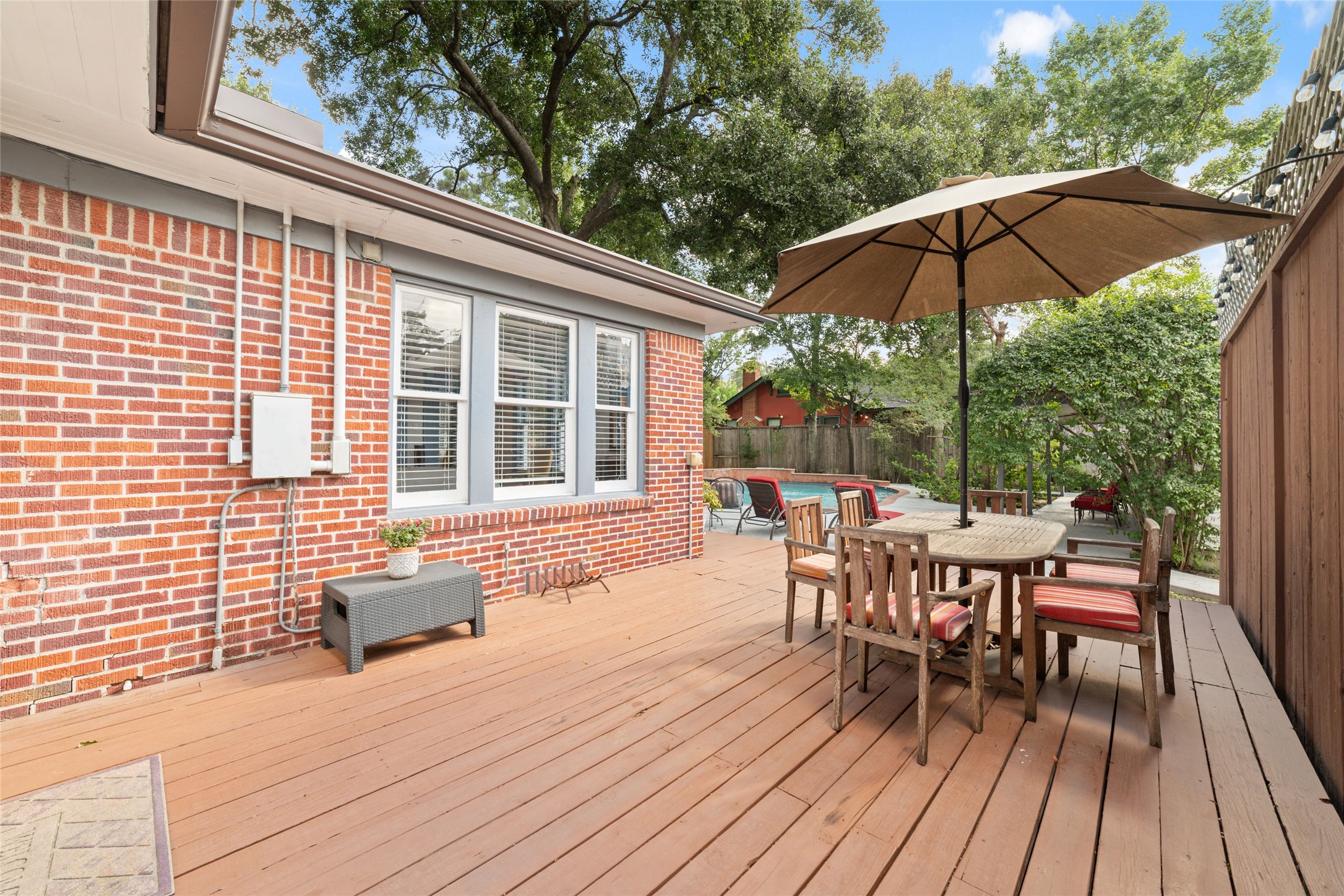 1613 California Street Houston, TX 77006 - Photo 7 of 50 French doors open onto an expansive deck that naturally becomes another living space, overlooking the heated saltwater pool, spa, and gardens that make this property feel like a private retreat.