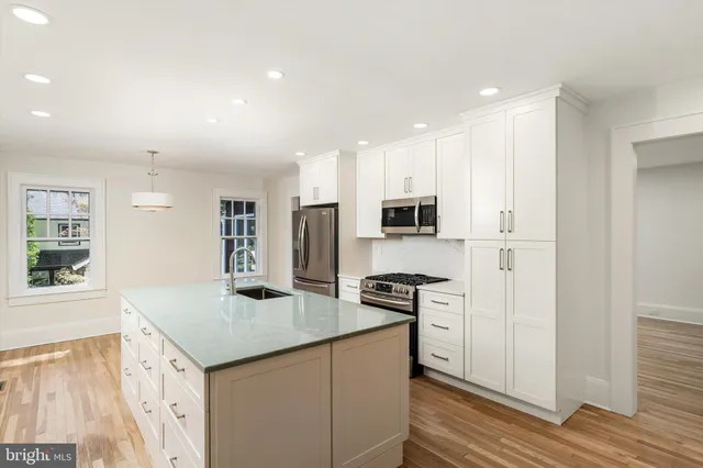 a kitchen with stainless steel appliances granite countertop a sink and a refrigerator