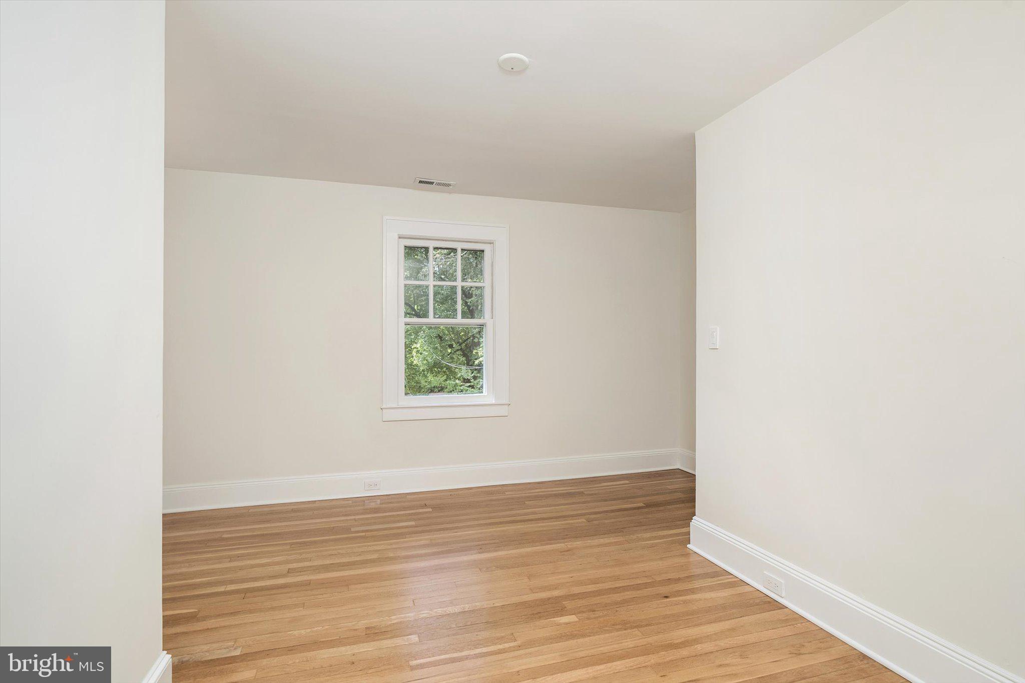 2148 Pennington Road Ewing, NJ 08638 - Photo 17 of 30 a view of an empty room with wooden floor and a window