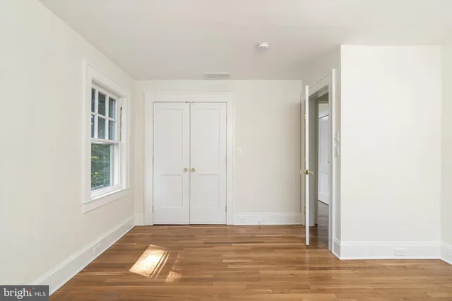 a view of a livingroom with wooden floor and a window