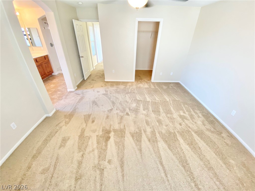 8569 Rhamus Court Las Vegas, NV 89149 - Photo 27 of 35 A spacious primary bedroom featuring plush carpeting and direct access to an en-suite bath.