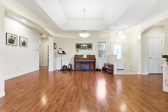 a view of a room with wooden floor a ceiling fan and window