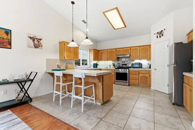 a kitchen with stainless steel appliances granite countertop a stove top oven a sink a counter top space and cabinets