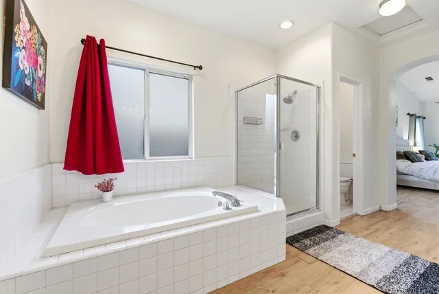 a bathroom with a tub a shower and a sink