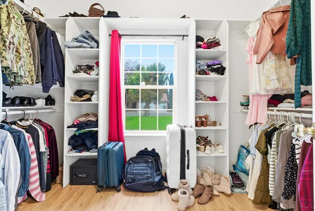 a view of walk in closet with clothes and shoes