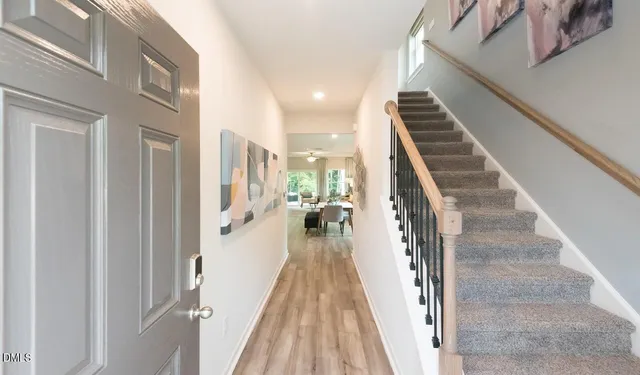 a view of a hallway with wooden floor and staircase