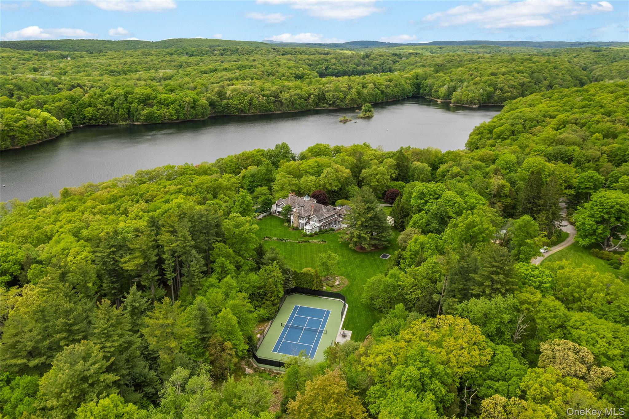 63 Old Mill River Road Pound Ridge, NY 10576 - Photo 1 of 47 a view of a lake with a mountain in the background