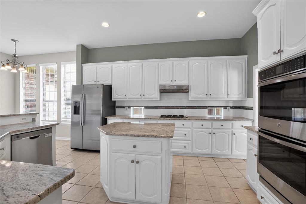 111 Ripplewood Coppell, TX 75019 - Photo 12 of 34 Kitchen featuring white cabinetry, light-toned countertops, tile flooring, and integrated stainless steel appliances