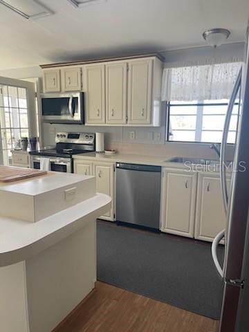 42 Seminole Path Wildwood, FL 34785 - Photo 30 of 59 a kitchen with stainless steel appliances a sink a stove a microwave a sink a refrigerator and cabinets